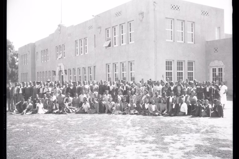 Large group of people gathered in front of a historic school building, celebrating Black education leaders in Arizona