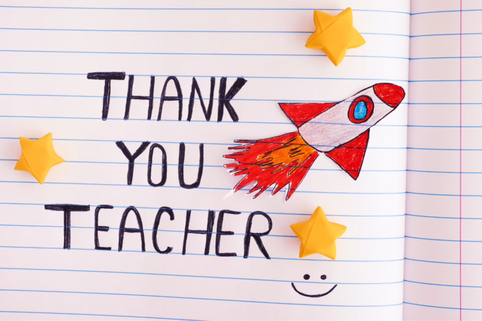 Thank You Teacher" written on lined paper with a rocket drawing, yellow stars, and a smiley face