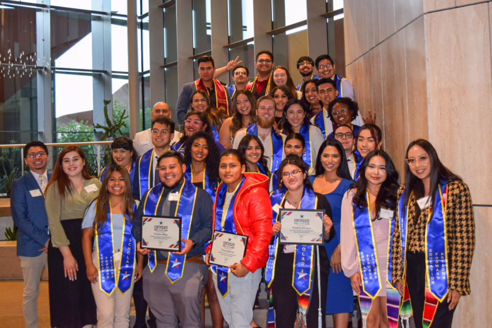Group of Education Forward Arizona Scholars with certificates, wearing blue stoles, celebrating college graduation
