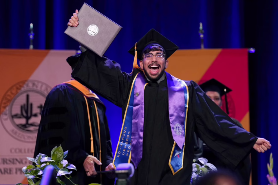 Graduate in cap and gown celebrates with diploma on stage, representing Arizona's Achieve60AZ education goal