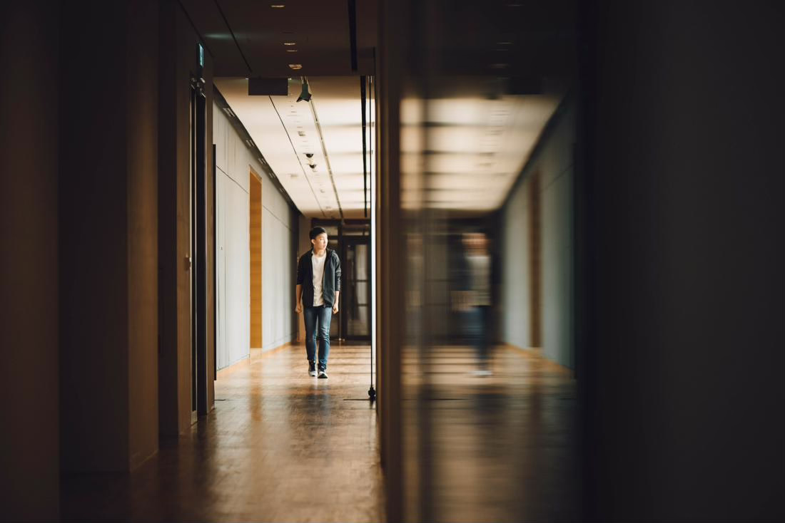 A person walks down a dimly lit hallway with reflections on the right wall. Text: "Use Fit and Match to Increase Students ...